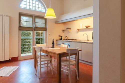 a kitchen with a wooden table and chairs at Borgo Syrah in Cortona