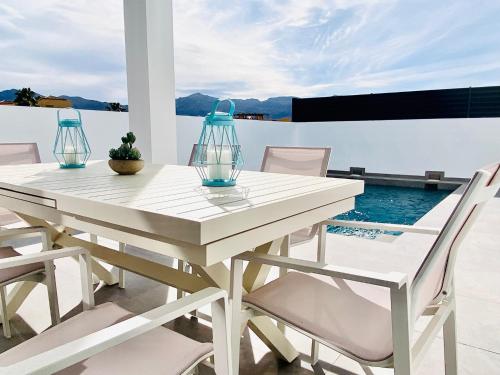 Los GallardosにあるHorizon Sierra&Mar Los Gallardosの白いテーブル(花瓶2本、椅子付)が備わるパティオ