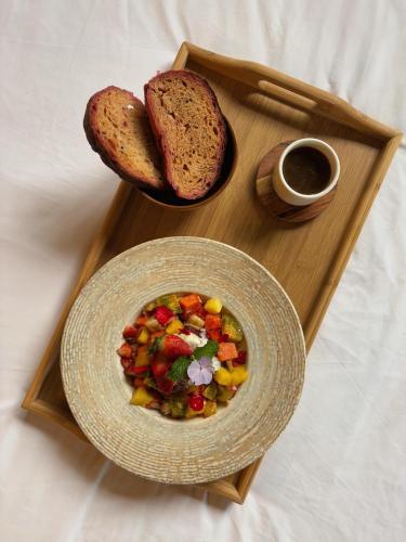 a wooden tray with a plate of food and bread at Hotel Finca Lerida Coffee Plantation and Boutique Hotel in Boquete