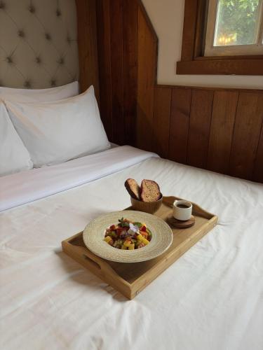 a tray with a plate of food and bread on a bed at Hotel Finca Lerida Coffee Plantation and Boutique Hotel in Boquete