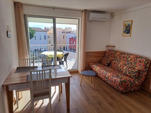 un salon avec un canapé et une table dans l'établissement Port Brescou III, T2 au centre port avec parking et clim, au Cap d'Agde