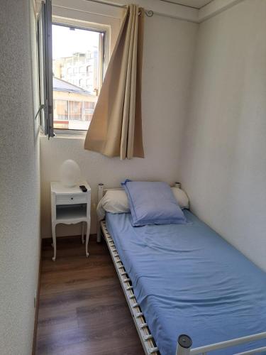 une petite chambre avec un lit et une fenêtre dans l'établissement Port Brescou III, T2 au centre port avec parking et clim, au Cap d'Agde