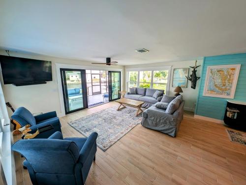 a living room with couches and chairs and a tv at The Fish Shack in Saint James City