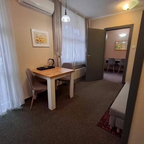 a room with a table and chairs and a room with a bed at Hotel Unicornis in Eger
