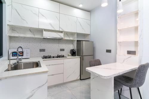 a white kitchen with a sink and a refrigerator at Ukulhas Sands in Ukulhas