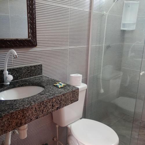 a bathroom with a toilet and a sink and a shower at Suítes na Beira do mar in Canavieiras