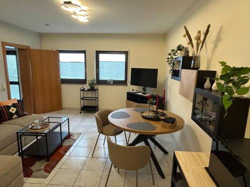 a living room with a table and a couch at Modernes ruhiges Apartment in Scheidt, Uni-Nähe in Saarbrücken