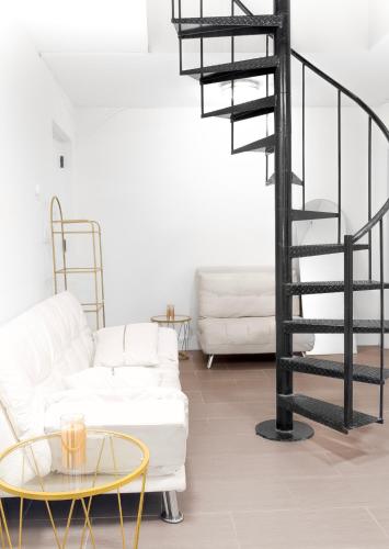 a living room with white furniture and a spiral staircase at Beachh - Ocean Stay - Blue3090 in Brooklyn