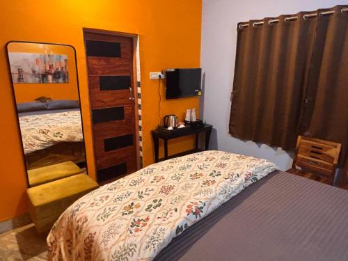a bedroom with a bed and a mirror at Dee Dash Inn in Bhubaneshwar