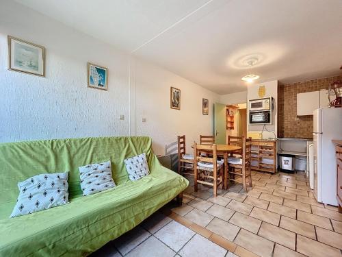un salon avec un canapé vert et une cuisine dans l'établissement 3085- T2 dans résidence piscine, à Argelès-sur-Mer