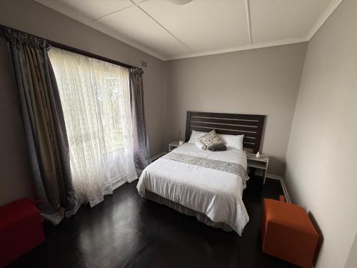 a bedroom with a bed and a large window at Vumasky in Ladysmith