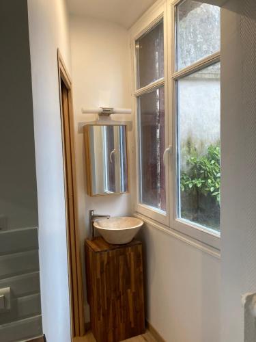 une salle de bain avec un lavabo et une fenêtre dans l'établissement Little Home Versailles, à Versailles