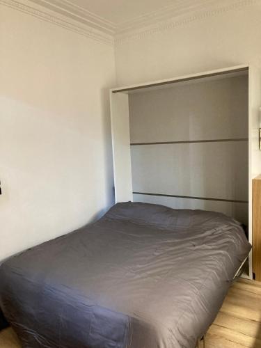 une chambre avec un grand lit dans une pièce dans l'établissement Little Home Versailles, à Versailles