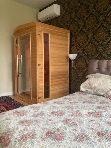 a bedroom with a bed and a wooden cabinet at Apartamentai Rusnėje , Nemuno 13 in Rusnė