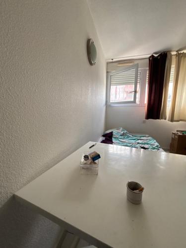 un comptoir blanc dans une pièce avec une table dans l'établissement Appartement cosy 2 pièce, à Perpignan