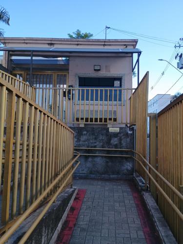 a house with a wooden fence and a walkway at Nosso apê in Pindamonhangaba