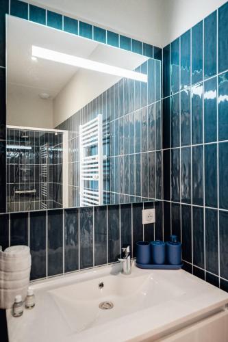 une salle de bain avec un lavabo et un miroir dans l'établissement Maison Bleue Ouest, à Saint-Julien-en-Born