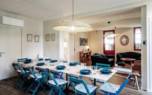 une salle à manger avec une table et des chaises bleues dans l'établissement Maison Bleue Ouest, à Saint-Julien-en-Born