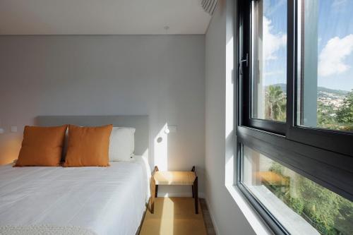 a bedroom with a bed and a large window at Casa de Viriato in Funchal