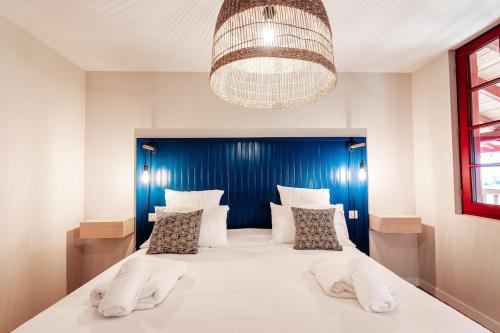 une chambre avec un grand lit avec une tête de lit bleue dans l'établissement Maison Bleue Ouest, à Saint-Julien-en-Born