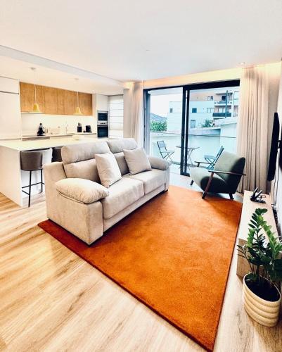 a living room with a couch and a kitchen at Casa de Viriato in Funchal
