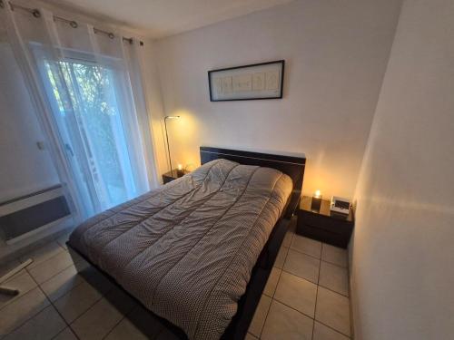 un petit lit dans une chambre avec une fenêtre dans l'établissement Le Standing - Fréjus, à Fréjus