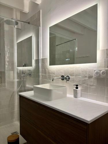 une salle de bain avec un lavabo blanc et un miroir dans l'établissement Jolie maison en centre ville avec climatisation grand lit double, à Arles
