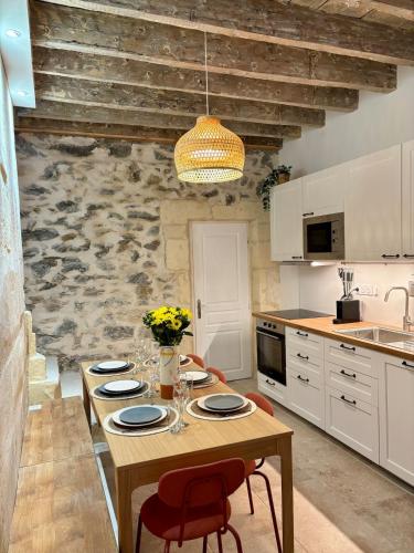 une cuisine avec une table en bois et des plaques de cuisson. dans l'établissement Jolie maison en centre ville avec climatisation grand lit double, à Arles