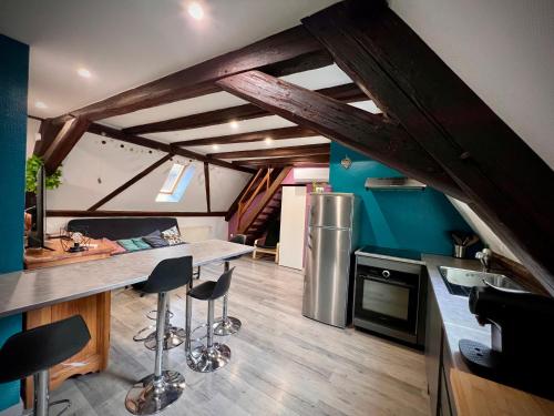 une cuisine avec un comptoir et des tabourets dans une pièce dans l'établissement Gîte du Figuier 4 à 6 personnes Sélestat Centre-Alsace, à Sélestat