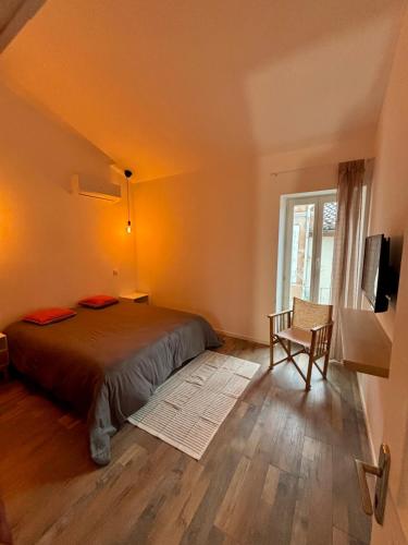 une chambre avec un lit, une fenêtre et une chaise dans l'établissement Jolie maison en centre ville avec climatisation grand lit double, à Arles