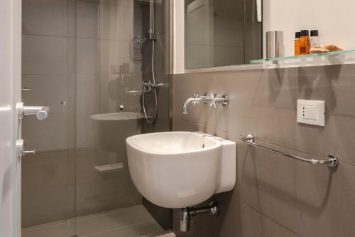 a bathroom with a white sink and a shower at Borgo Syrah in Cortona