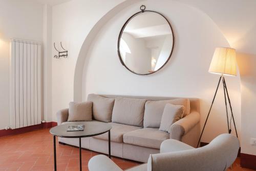 a living room with a couch and a mirror at Borgo Syrah in Cortona