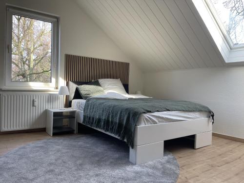 a bedroom with a large bed with a window at Gemütliches Mansarden-Apartment mit 2 Schlafzimmern & separater Küche in Herne