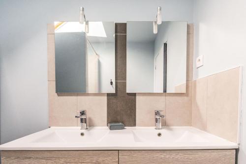 une salle de bain avec deux lavabos et un miroir dans l'établissement La Villa Tara, à Sarzeau
