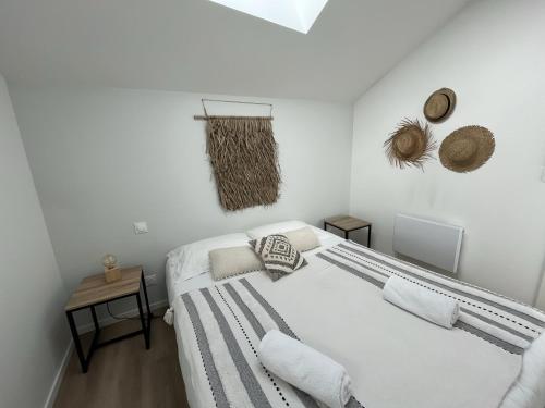 - une chambre blanche avec un lit et des oreillers dans l'établissement APPART-HOTEL n 3 avec terrasse, piscine, petit-dejeuner et parking privé, à Chouzelot
