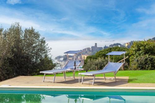 two chairs and a table next to a swimming pool at Villa il Mandorlo by VacaVilla in Passignano sul Trasimeno
