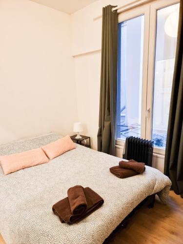 une chambre avec un lit avec deux serviettes dessus dans l'établissement EXIGEHOME-Versailles à 2 pas du château, à Versailles