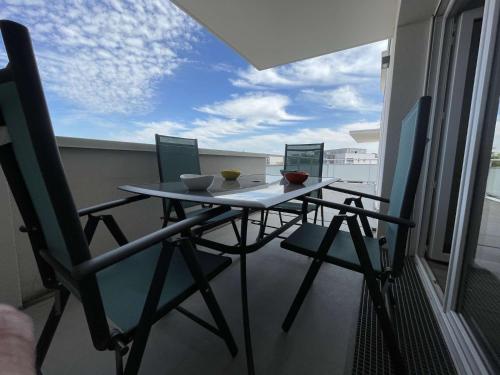 une table et des chaises sur un balcon avec vue dans l'établissement Appt 3 pièces LA ROCHELLE - LR670-303, à La Rochelle