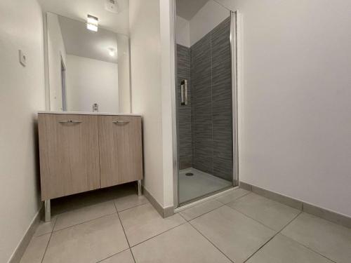 La salle de bains est pourvue d'une douche et d'une armoire en bois avec un miroir. dans l'établissement Appt 3 pièces LA ROCHELLE - LR670-303, à La Rochelle