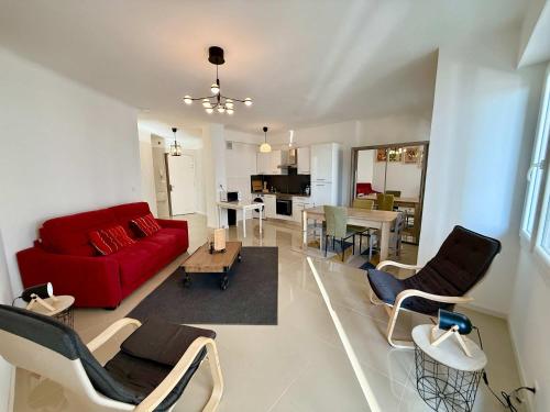- un salon avec un canapé rouge et une salle à manger dans l'établissement C083 Croisette - 1 chambre - Vue Epoustouflante, à Cannes