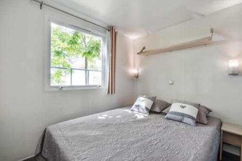 - une chambre avec un lit avec deux oreillers et une fenêtre dans l'établissement Mobile Home Camping Marvilla Parks Le Petit Mousse M028, à Vias