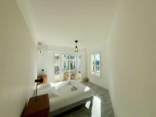 une chambre blanche avec un lit et une fenêtre dans l'établissement C083 Croisette - 1 chambre - Vue Epoustouflante, à Cannes