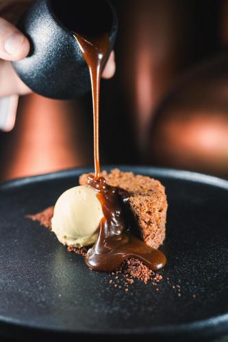 a person drizzling chocolate on a piece of food at Svalbard Hotell | Polfareren in Longyearbyen