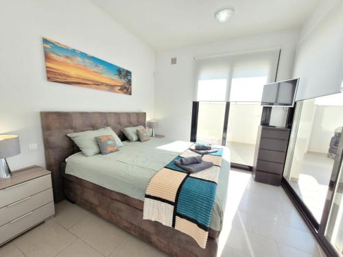 a bedroom with a large bed and a television at Casa Spruit in Rojales