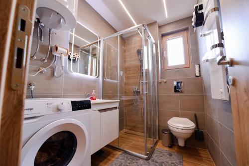 a bathroom with a shower and a washing machine at Gorski Elegance 1 in Zlatibor