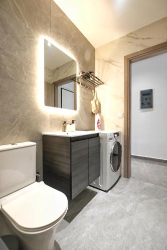 a bathroom with a toilet sink and a washing machine at Cozy Home With Cooking in Piraeus