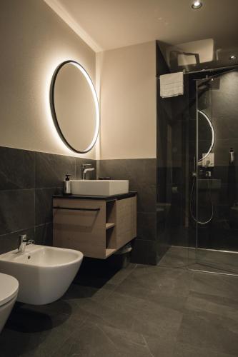 a bathroom with a sink and a mirror and a shower at Haunold Homes in San Candido