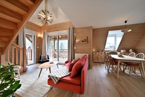 un salon avec un canapé rouge et une table dans l'établissement Superbe appartement - Face au lac, à Génos