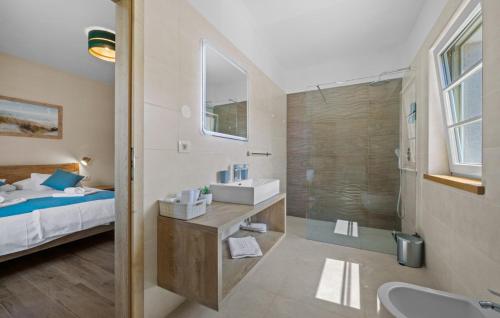 a bathroom with a bed and a sink and a shower at Beautiful Stone Villa Murine Istria in Murine