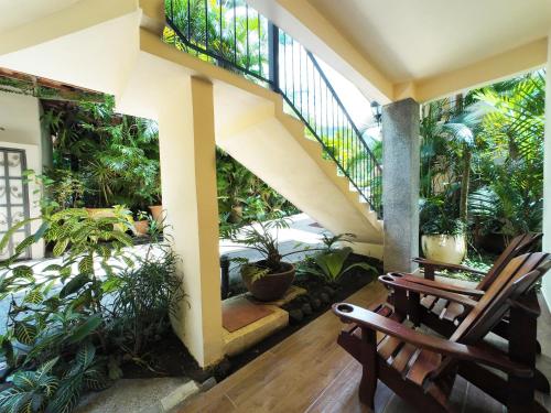 a porch with two chairs and a staircase with plants at Paradise Hot Springs - Thermal Water & Volcano Views in Fortuna